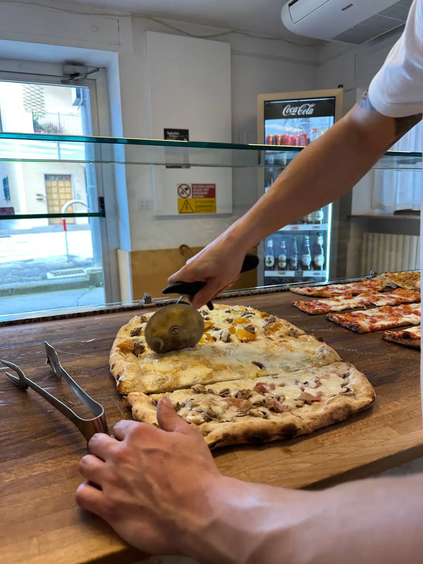 Pizza Pazza dopo la rinascita — bancone e vetrina su Viale Trieste